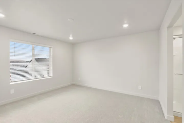 Spacious room featuring neutral carpeting and white wall finishes
