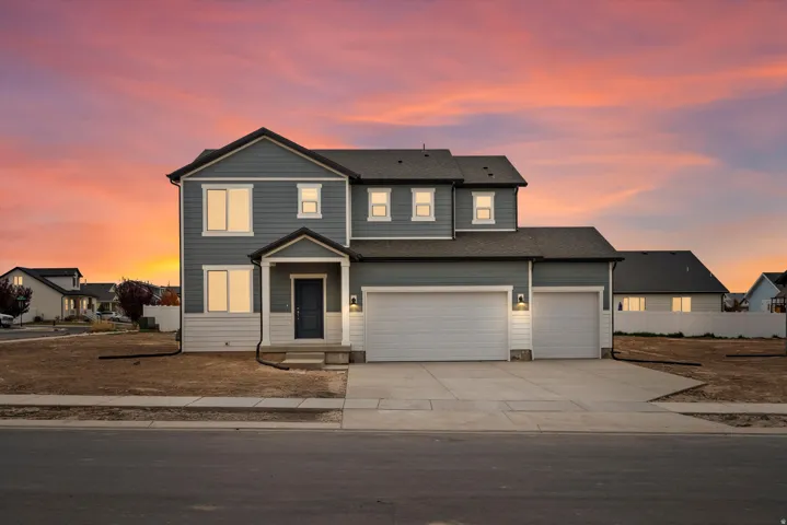 Two-story residence featuring a covered front porch, a two-car garage, and an additional single-car garage