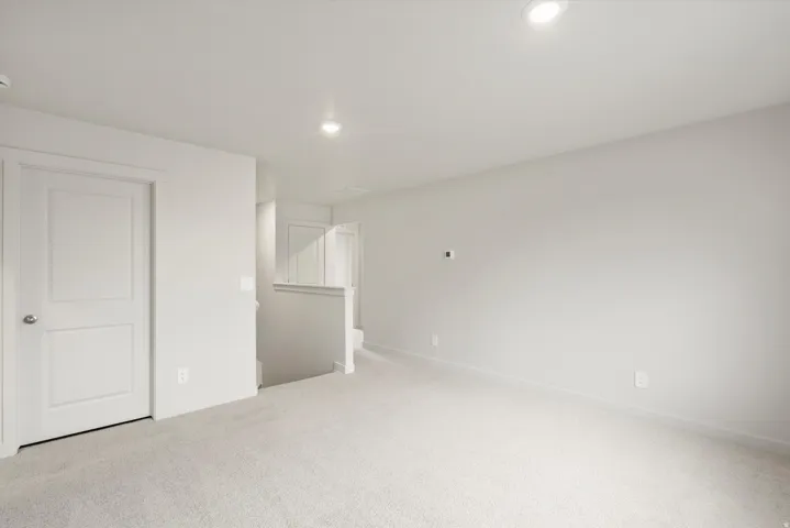Carpeted room with recessed lighting and neutral wall finishes