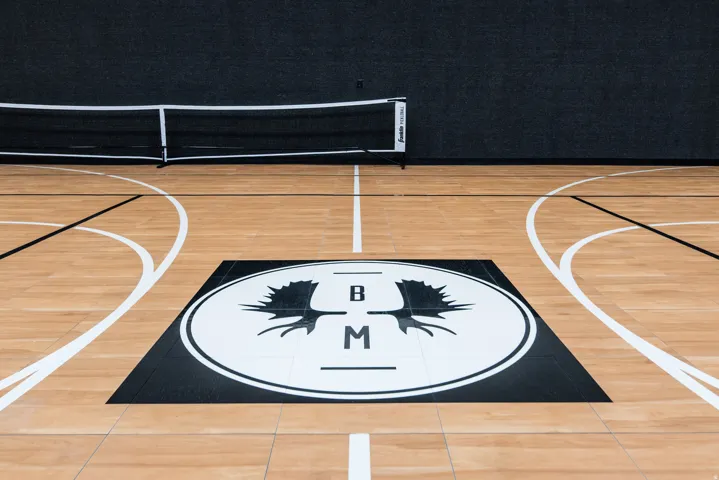 Indoor court featuring wood-finish flooring with court markings