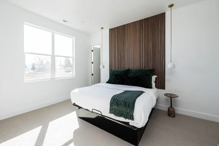 Bedroom featuring a wood slat accent wall, large picture window, recessed lighting, and soft carpet flooring