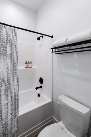 Bathroom featuring a white tub and shower combination with matte black fixtures
