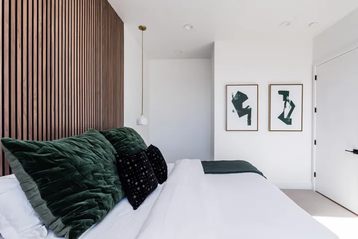 Accent wall featuring vertical wood paneling, recessed lighting, and a modern pendant light