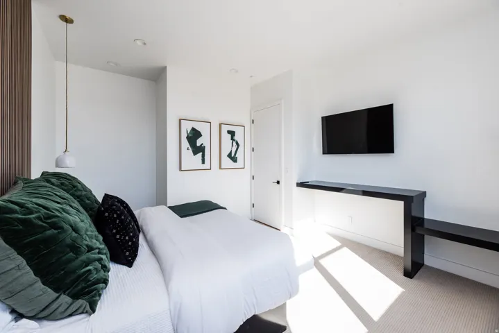 Neutral-toned wall finishes with recessed lighting and a built-in wall-mounted television