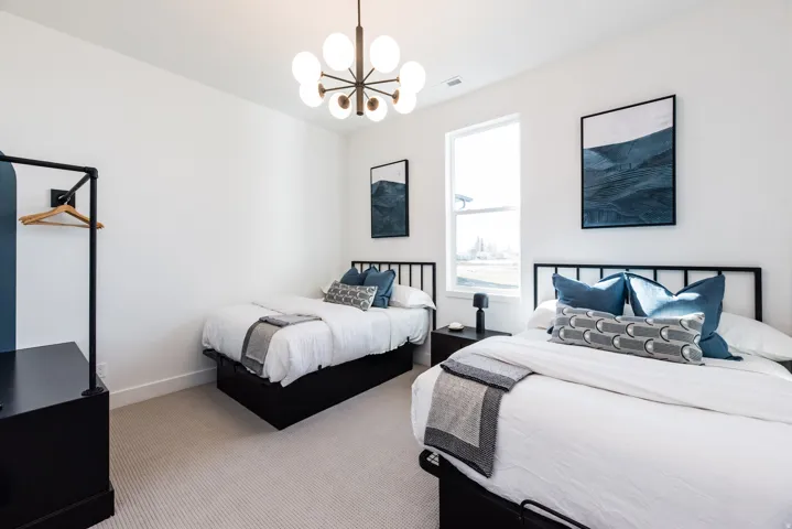 Light-filled room featuring a large window, carpeted flooring, and a modern ceiling light fixture