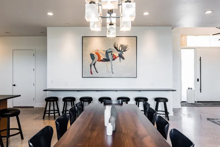 Spacious dining area featuring a modern chandelier, wood-finish flooring, and a built-in counter with seating