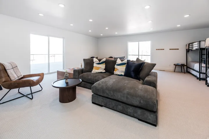 Spacious room featuring light-toned carpet flooring, bright white walls, and recessed lighting