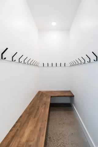 Entryway featuring a built-in L-shaped wood bench and concrete flooring