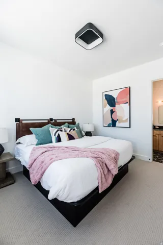 Neutral-toned carpeting extends throughout this room, featuring a modern ceiling light fixture