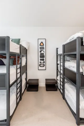 Carpeted room featuring two multi-level bunk beds with dark frames