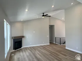 Spacious room featuring vaulted ceilings, recessed lighting, and wood-finish flooring
