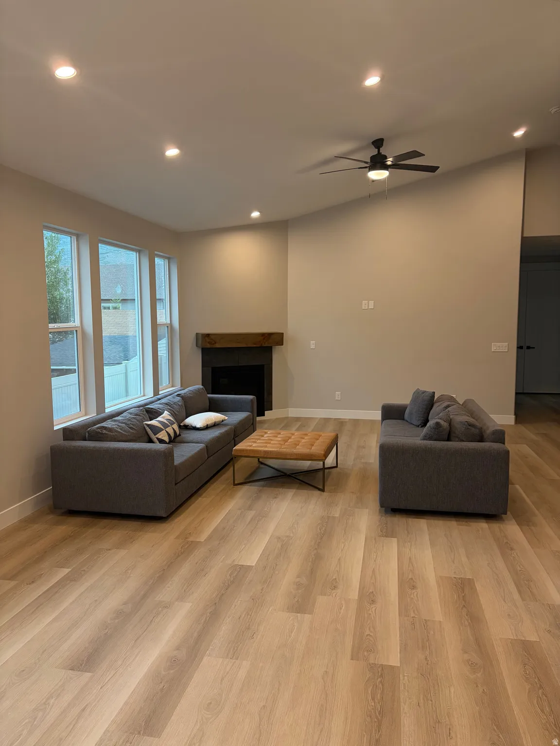Spacious living area featuring wood-finish flooring, recessed lighting, and a modern ceiling fan