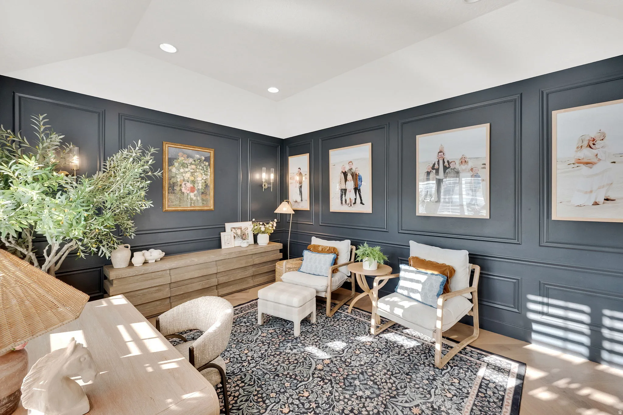 Interior room featuring dark paneled walls with sconce lighting, wood-finish flooring, and a decorative area rug