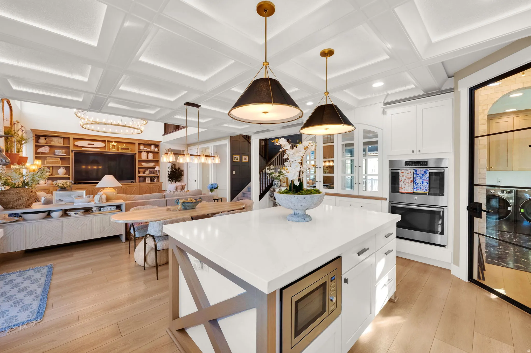 Expansive kitchen island with a built-in microwave, white cabinetry, and recessed lighting