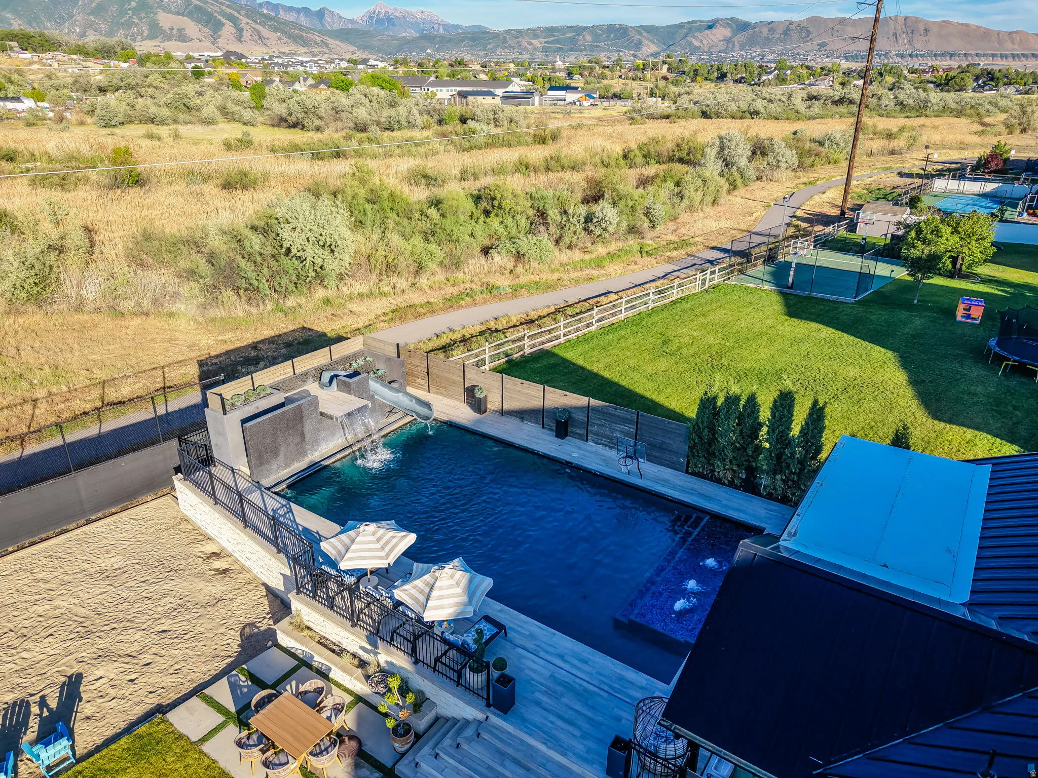 Contemporary outdoor living area featuring a rectangular pool with integrated slide and water features