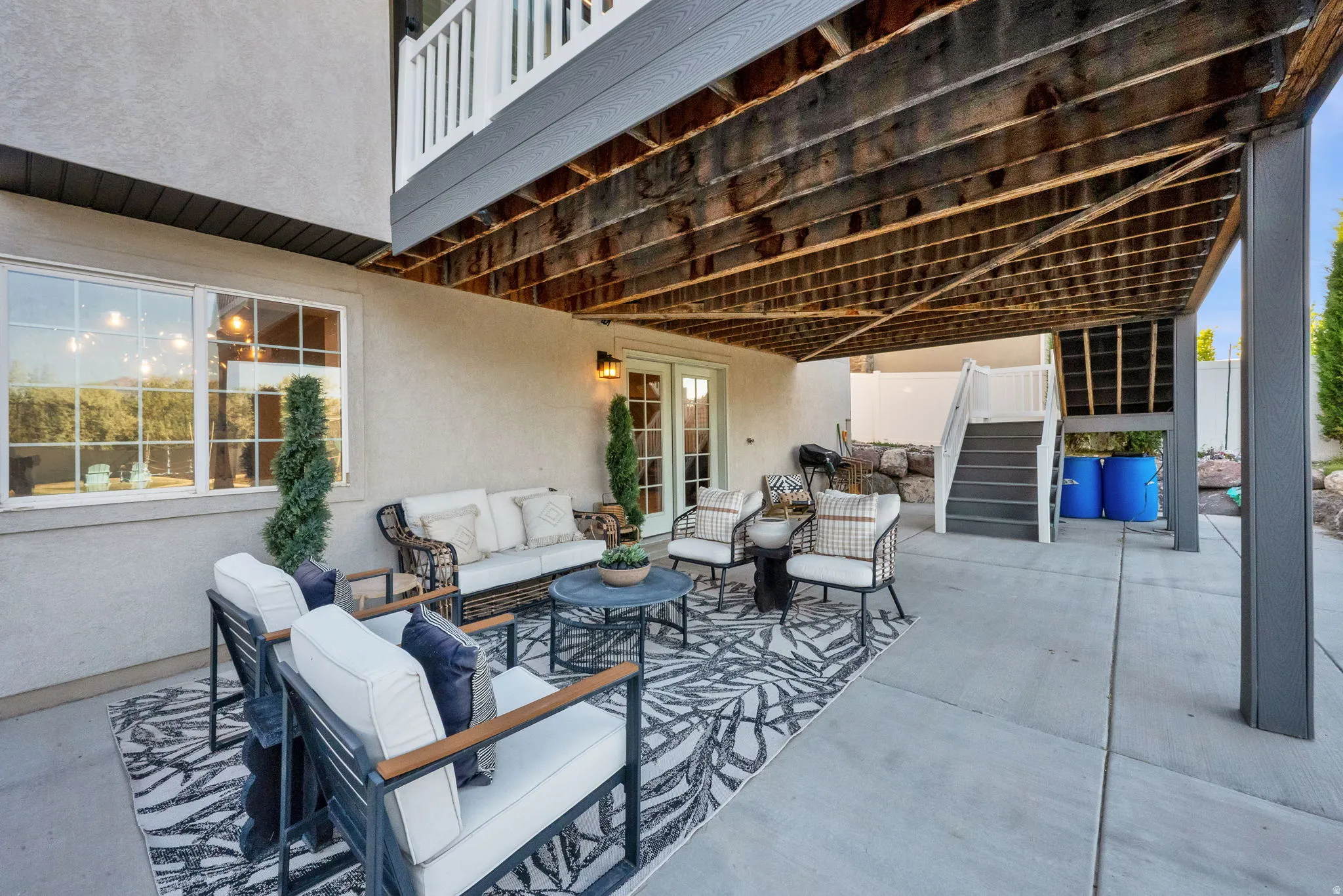 Covered concrete patio with overhead deck structure