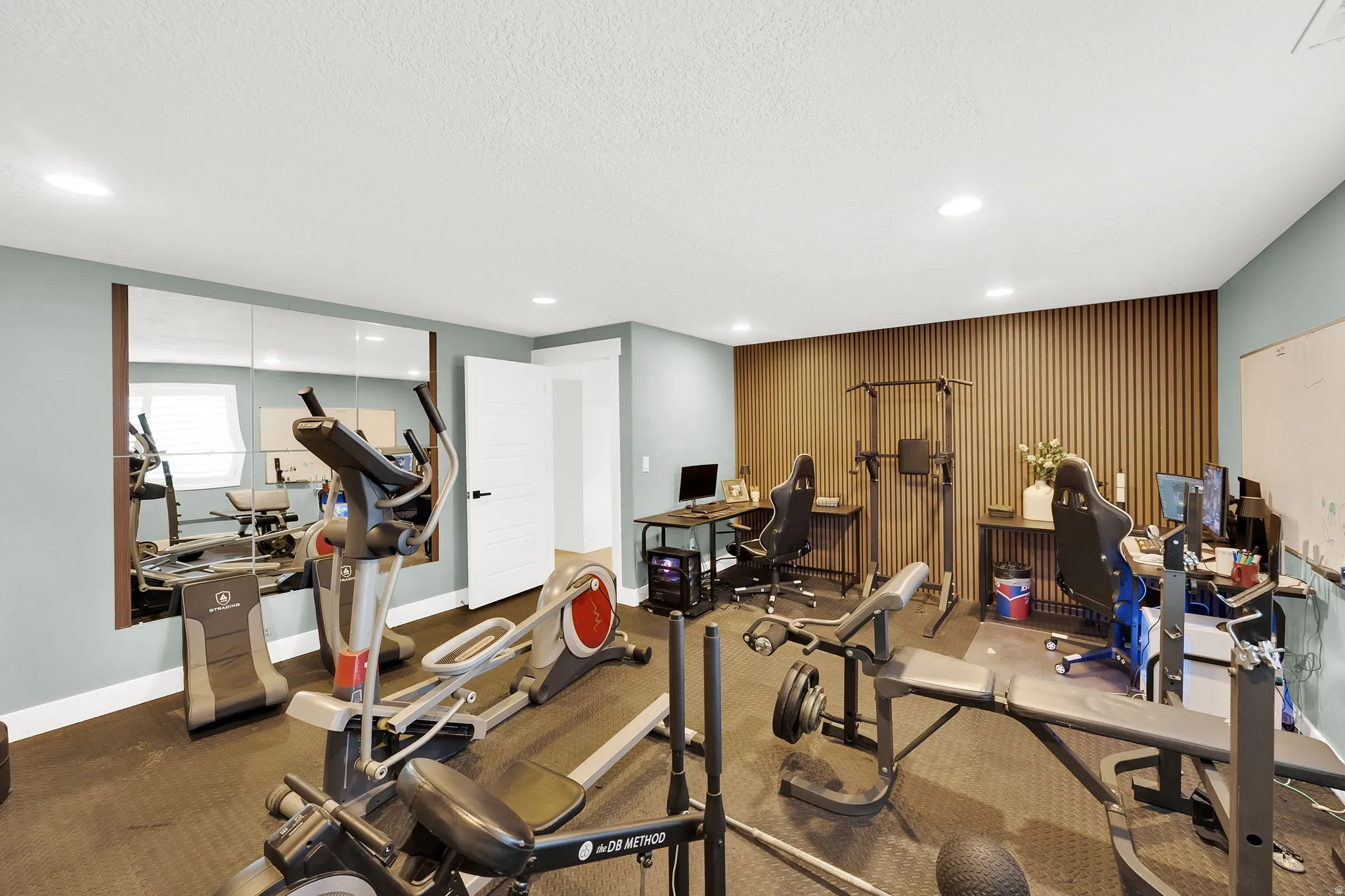 Versatile room featuring light blue walls, recessed lighting, and rubberized flooring