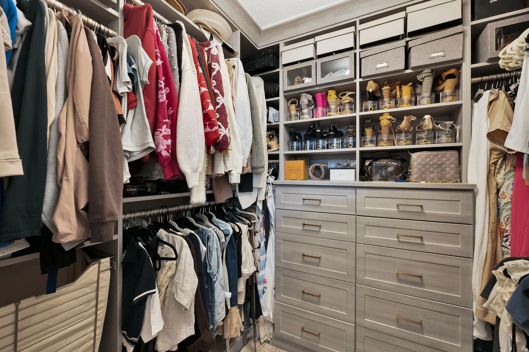 Custom closet organization system featuring light gray cabinetry