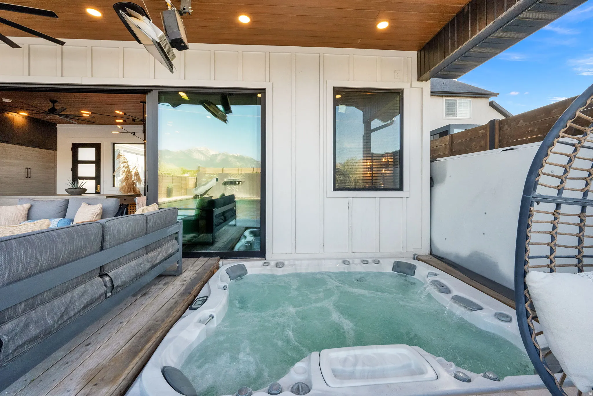 Outdoor hot tub situated on a wood-finish deck with a wood-paneled ceiling and recessed lighting