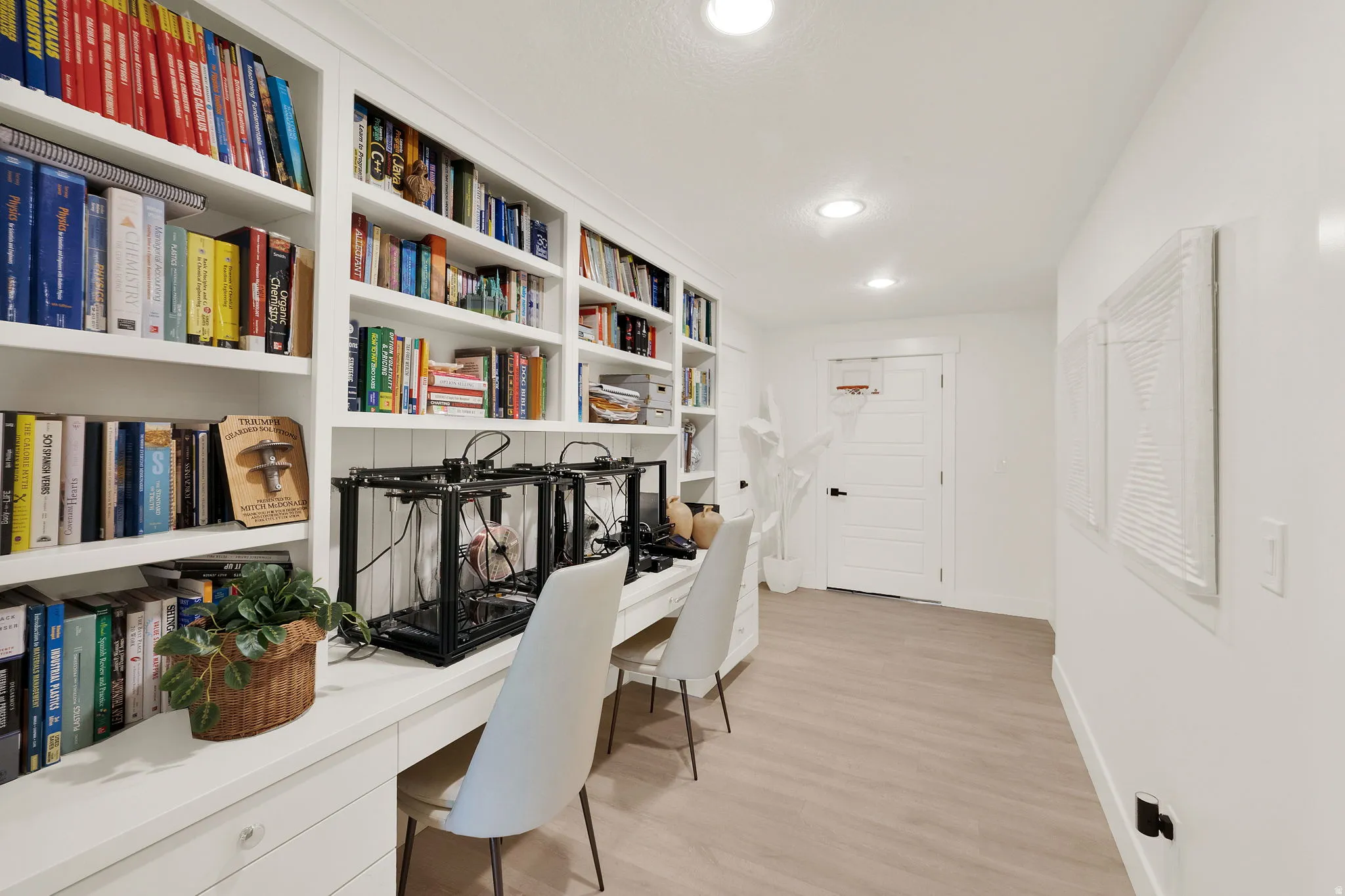 Integrated shelving and desk space featuring white cabinetry