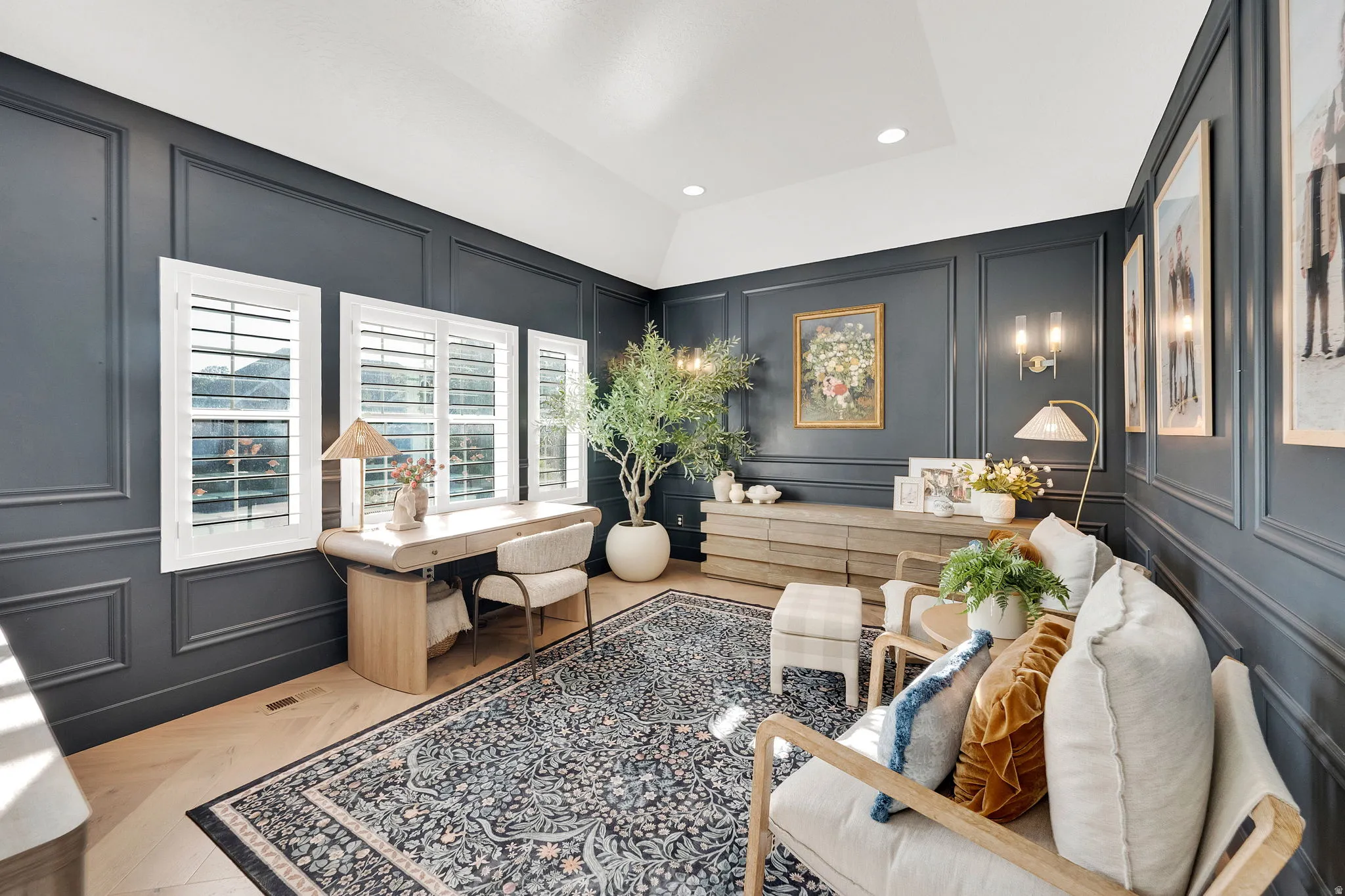 Paneled walls in a deep hue complement light wood-finish flooring