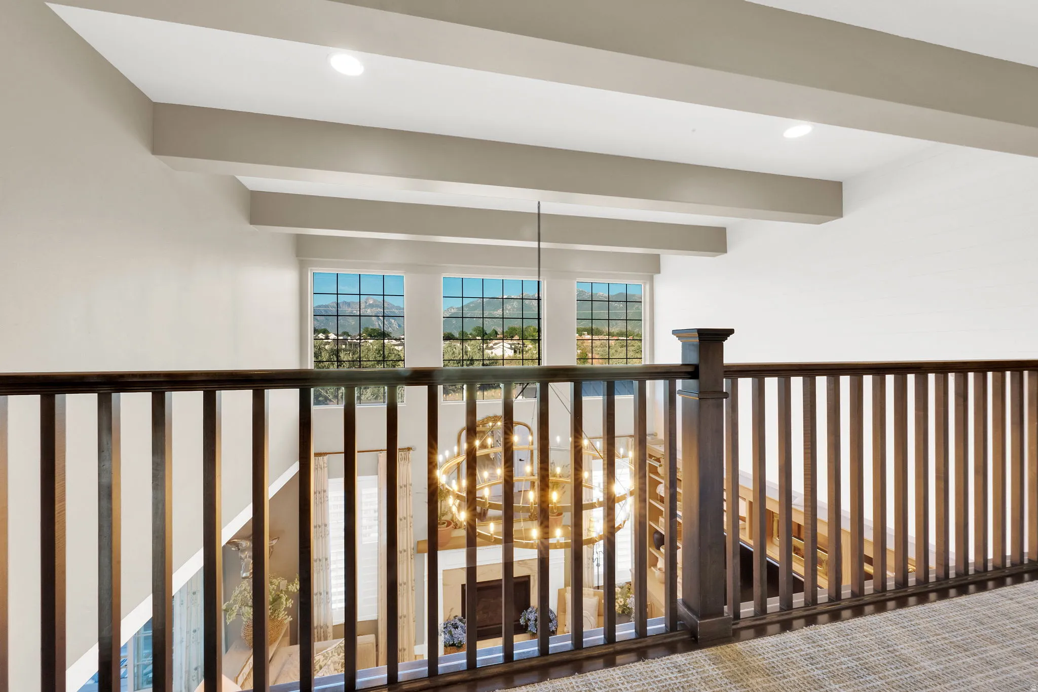 Upper-level landing featuring a dark wood spindle railing and carpeted flooring