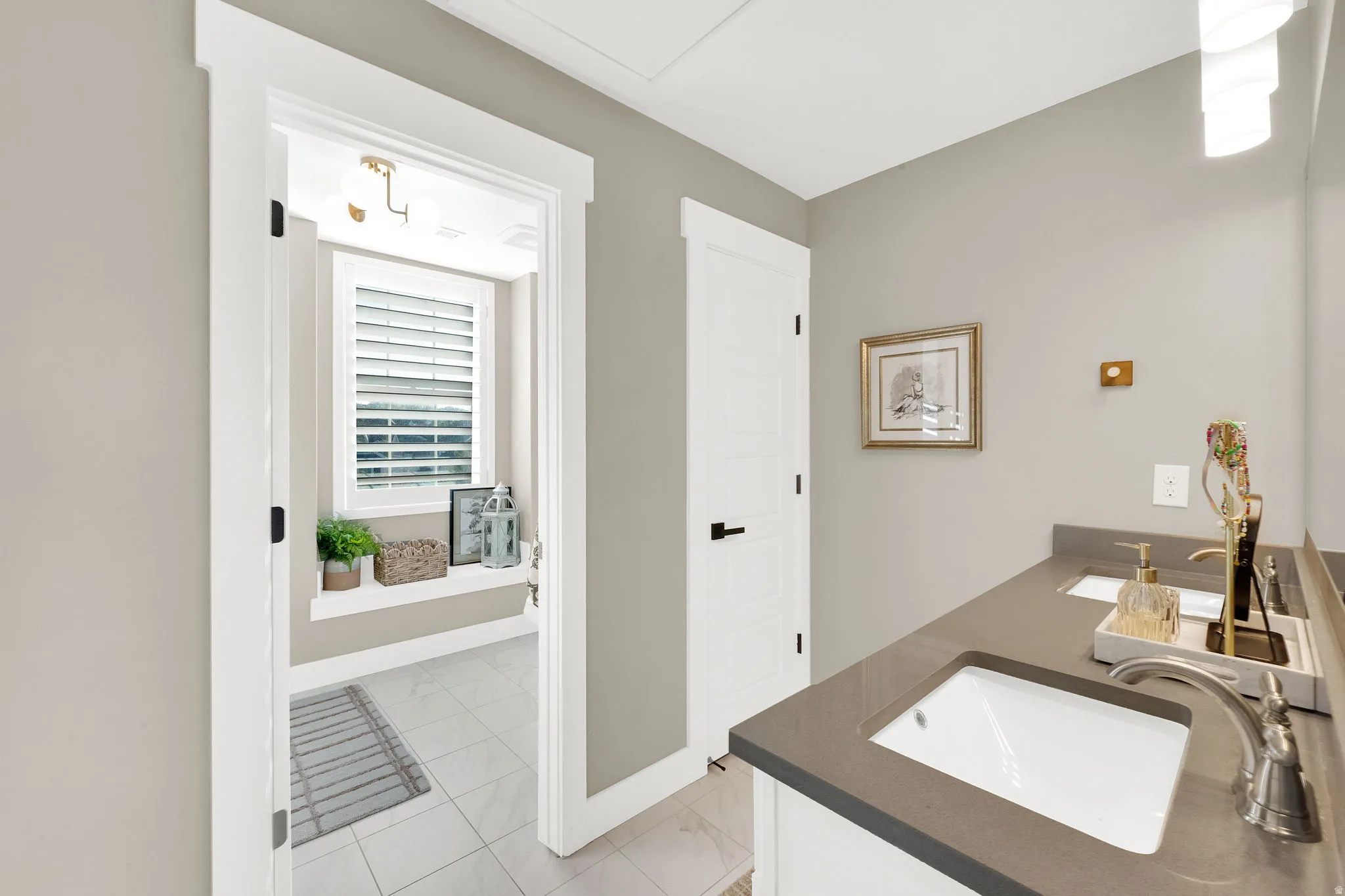 Double vanity featuring undermount sinks and dark countertops