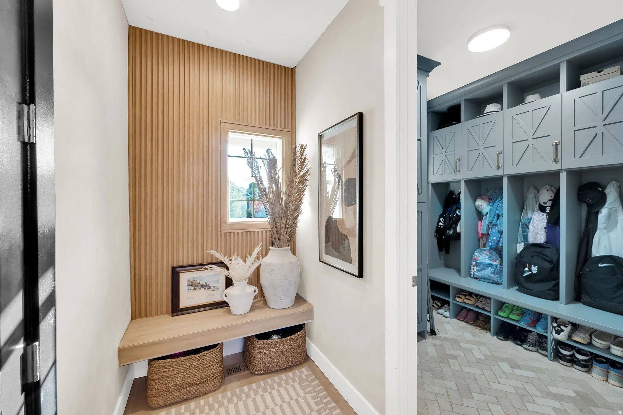 Entryway featuring a built-in wood-finish bench and a slatted accent wall