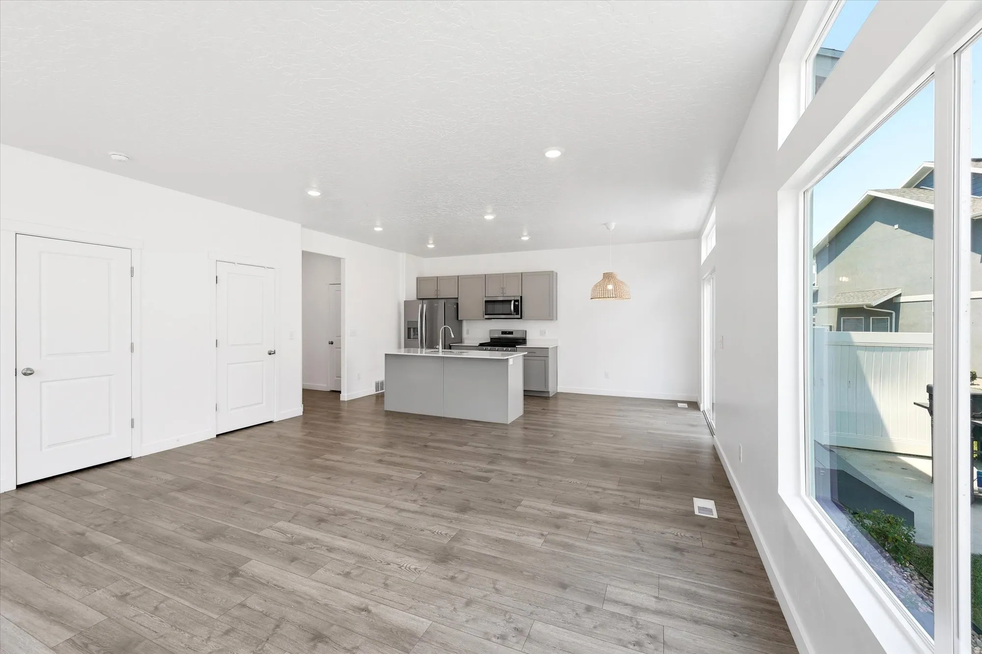 Open-concept living space featuring wood-finish flooring, recessed lighting, and a modern kitchen