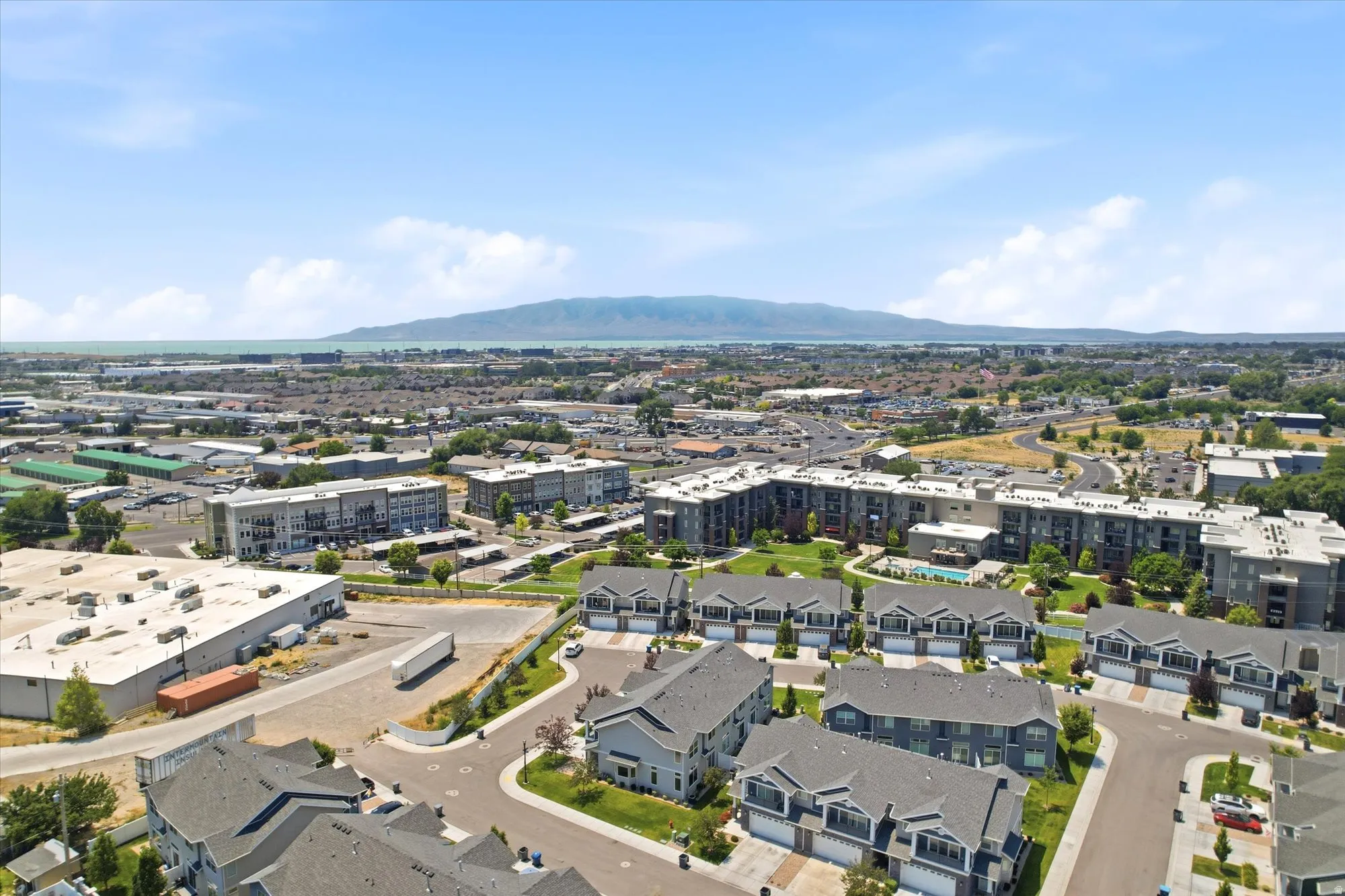 Aerial perspective showcasing a residential development with townhomes and multi-story apartment buildings