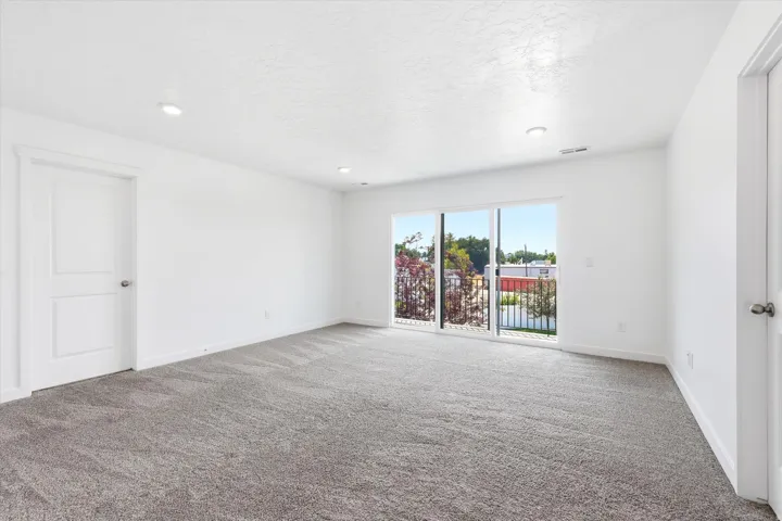 Spacious room with plush gray carpeting and white walls