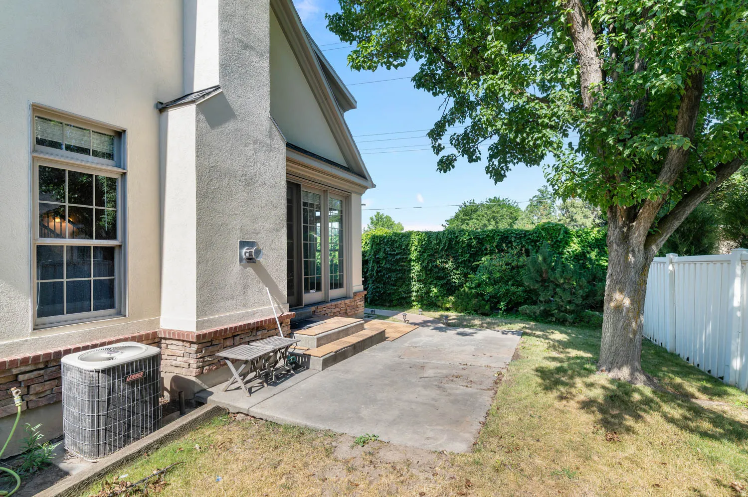 Exterior featuring stucco siding, a stone veneer foundation, and a prominent chimney