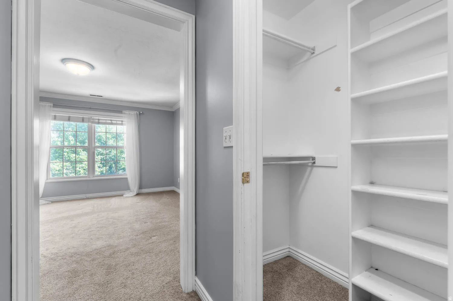 Bedroom entrance featuring light gray walls, white trim, and a flush mount ceiling light