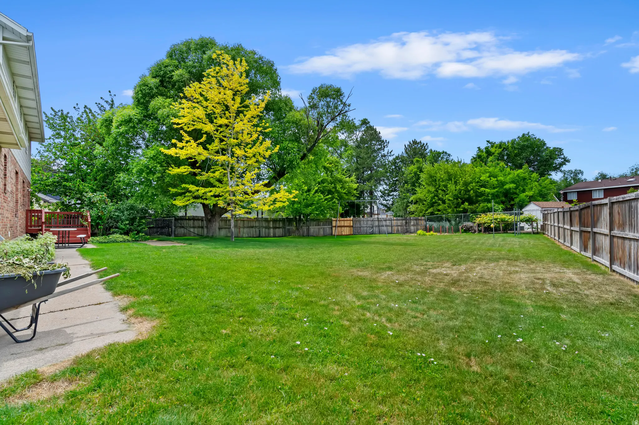 Expansive fenced backyard featuring a substantial lawn area