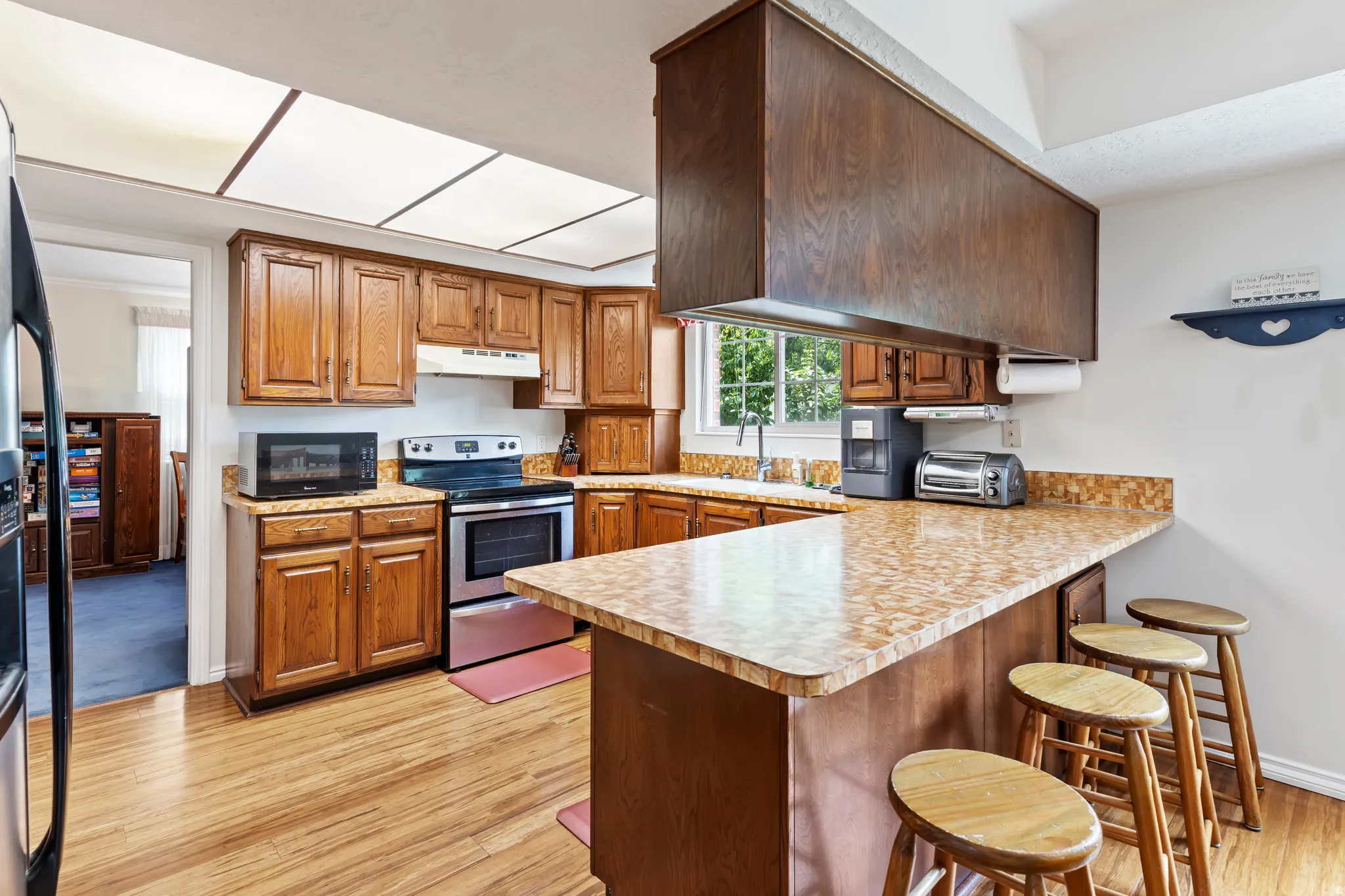Kitchen featuring wood cabinetry, stainless steel appliances, and a breakfast bar with seating