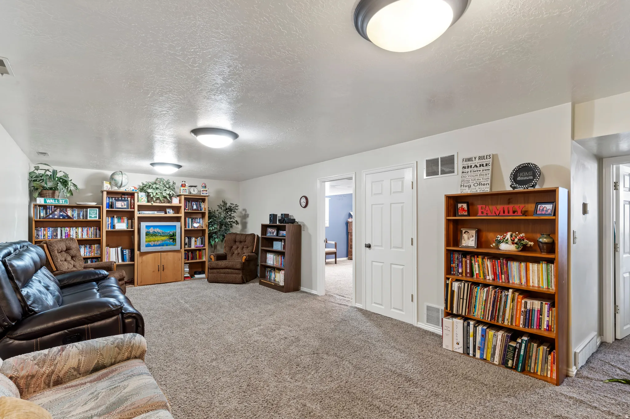 Spacious room featuring neutral carpet flooring, recessed lighting, and multiple doorways
