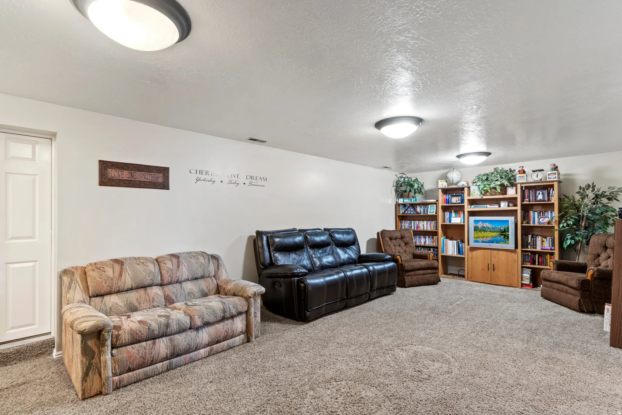 Spacious room featuring neutral wall paint, textured ceiling, and gray carpet flooring