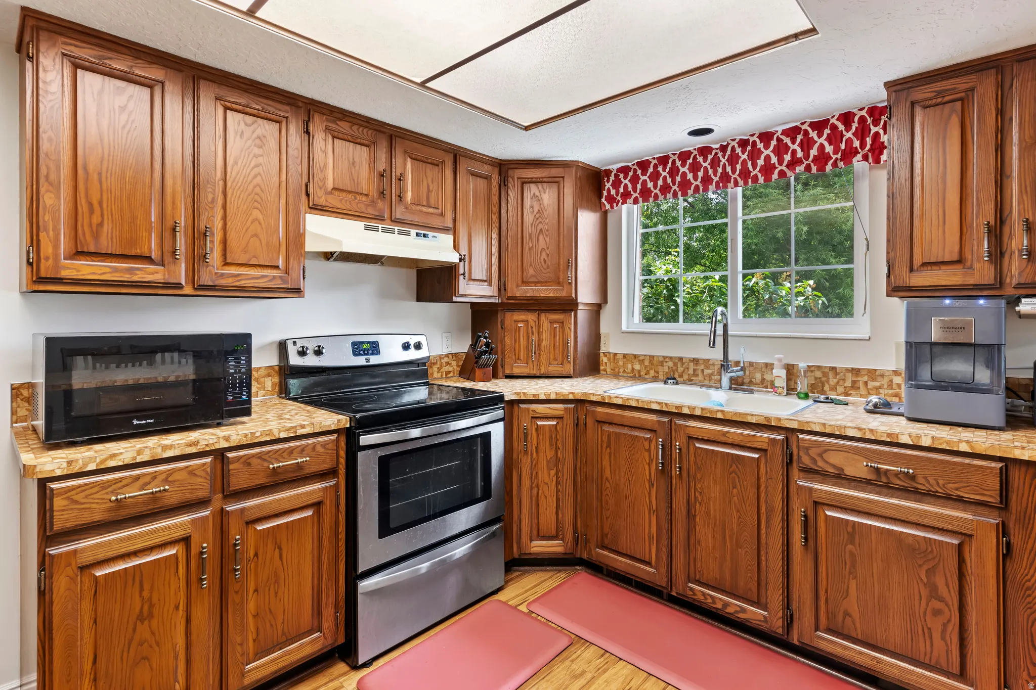 Kitchen featuring wood cabinetry, stone-finish countertops, and a tile backsplash
