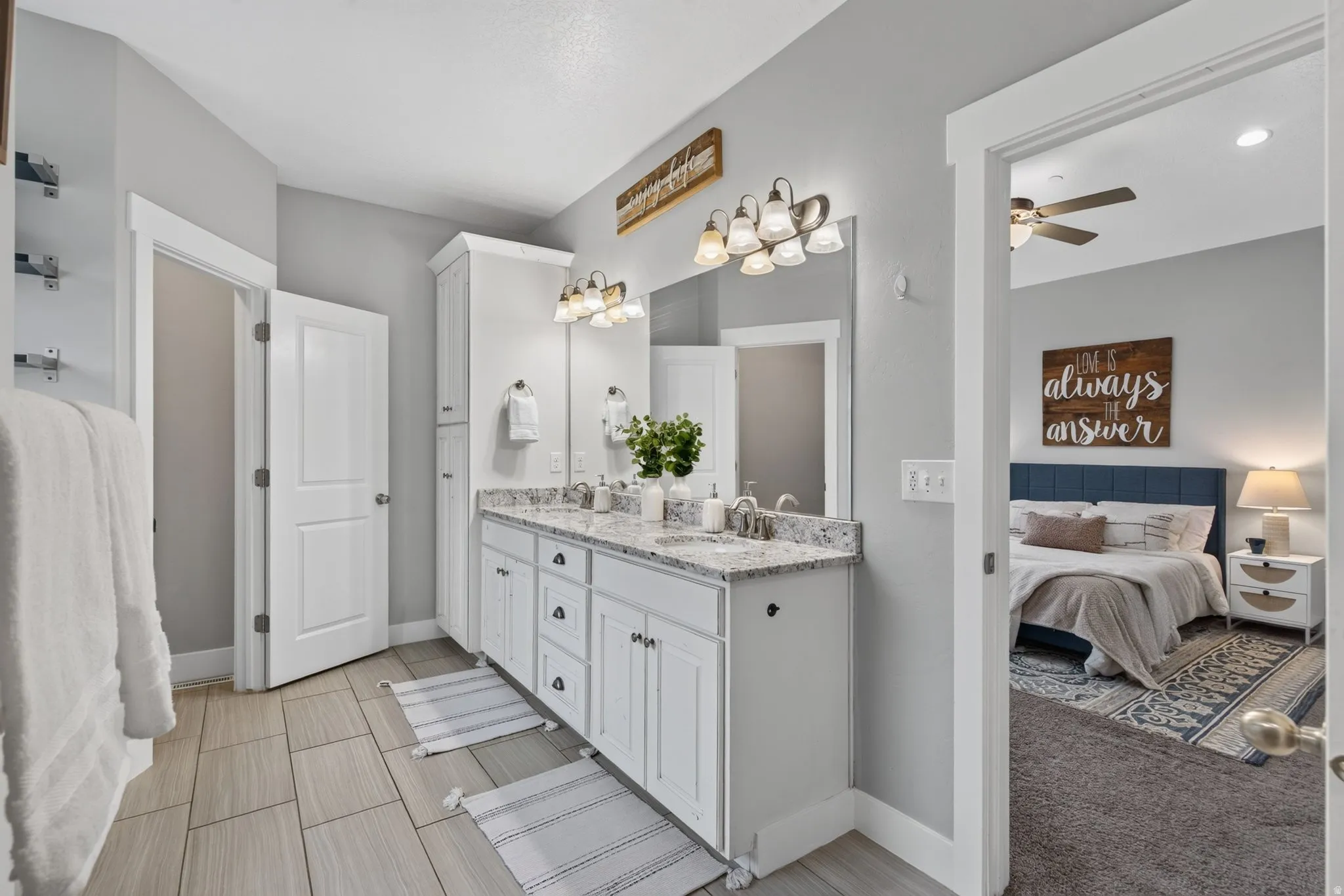 Master bathroom with dual vanity, granite countertop, tile flooring, walk-in shower, and direct connection to the primary suite.