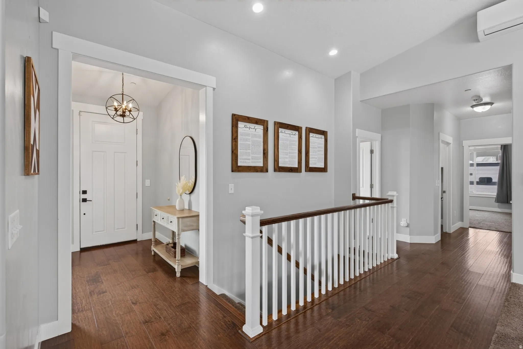 Welcoming main-level entry with wood flooring, open sightlines, natural light, and convenient access to the main living spaces.