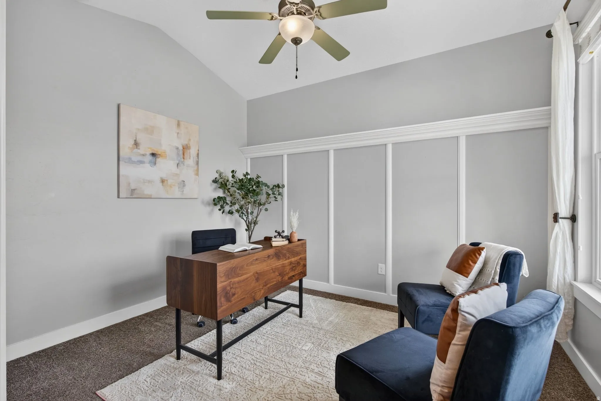 Sitting Room just off the front door featuring vaulted ceilings and a ceiling fan
