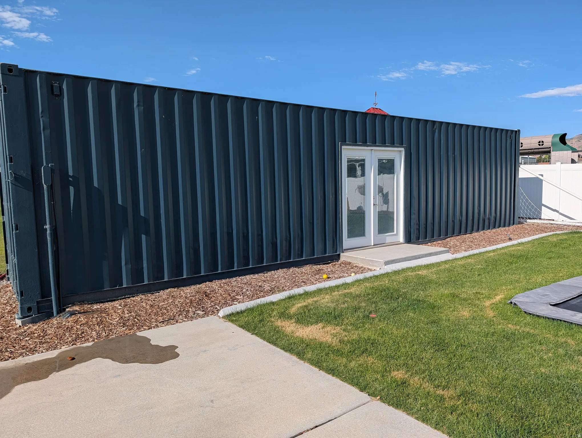 Heated gym. Corrugated metal siding structure with white double doors