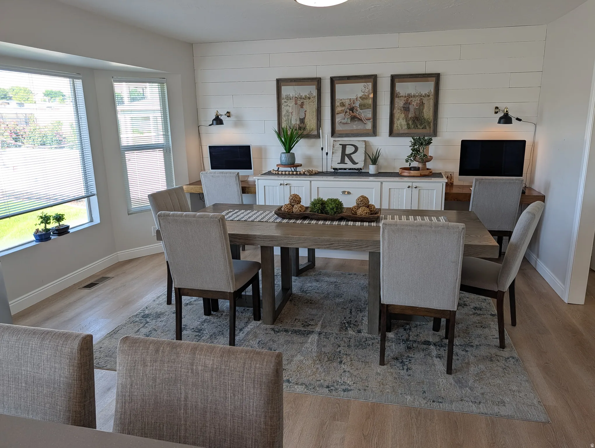 Dining area with wood-finish flooring and a bay window