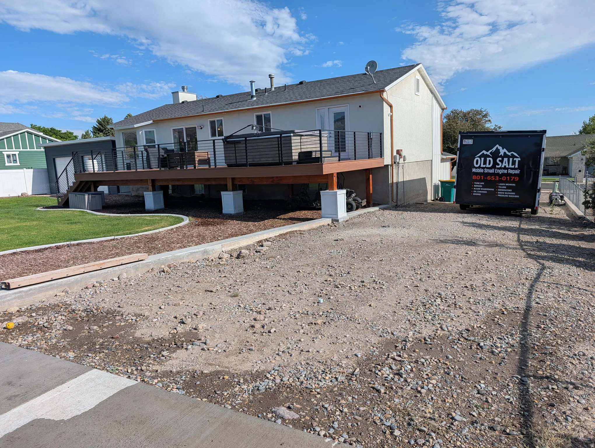 RV parking. Rear exterior featuring a large elevated deck with dark railings, a built-in spa, and a sliding glass door