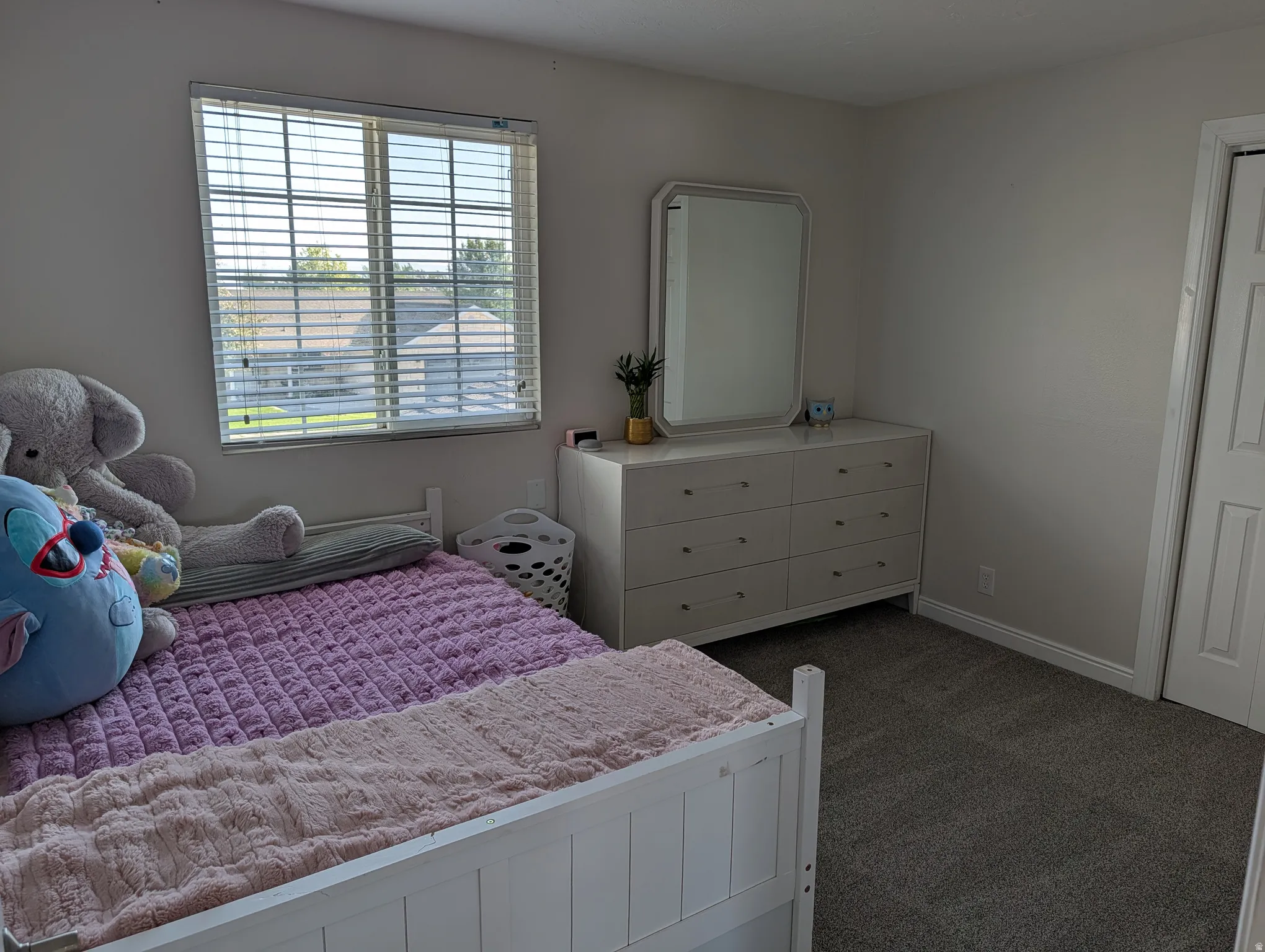 Room featuring a window with horizontal blinds, light gray wall paint, and gray carpeting