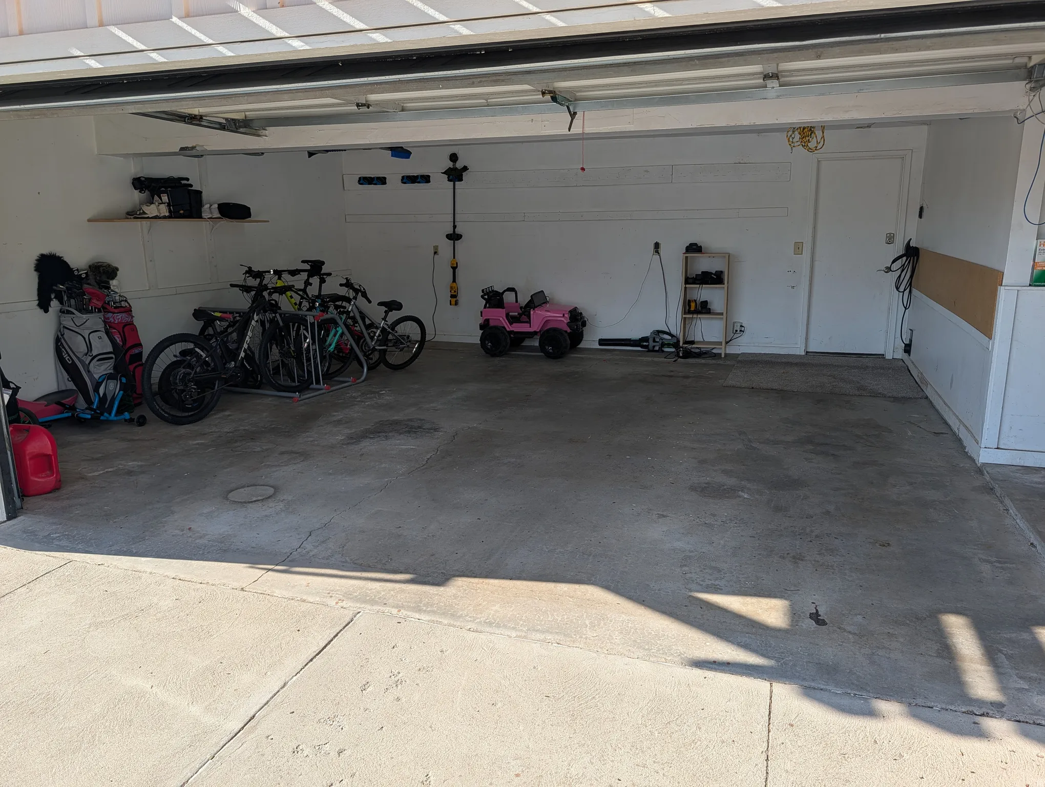 Spacious garage interior featuring a concrete floor, white painted walls, and an overhead garage door mechanism