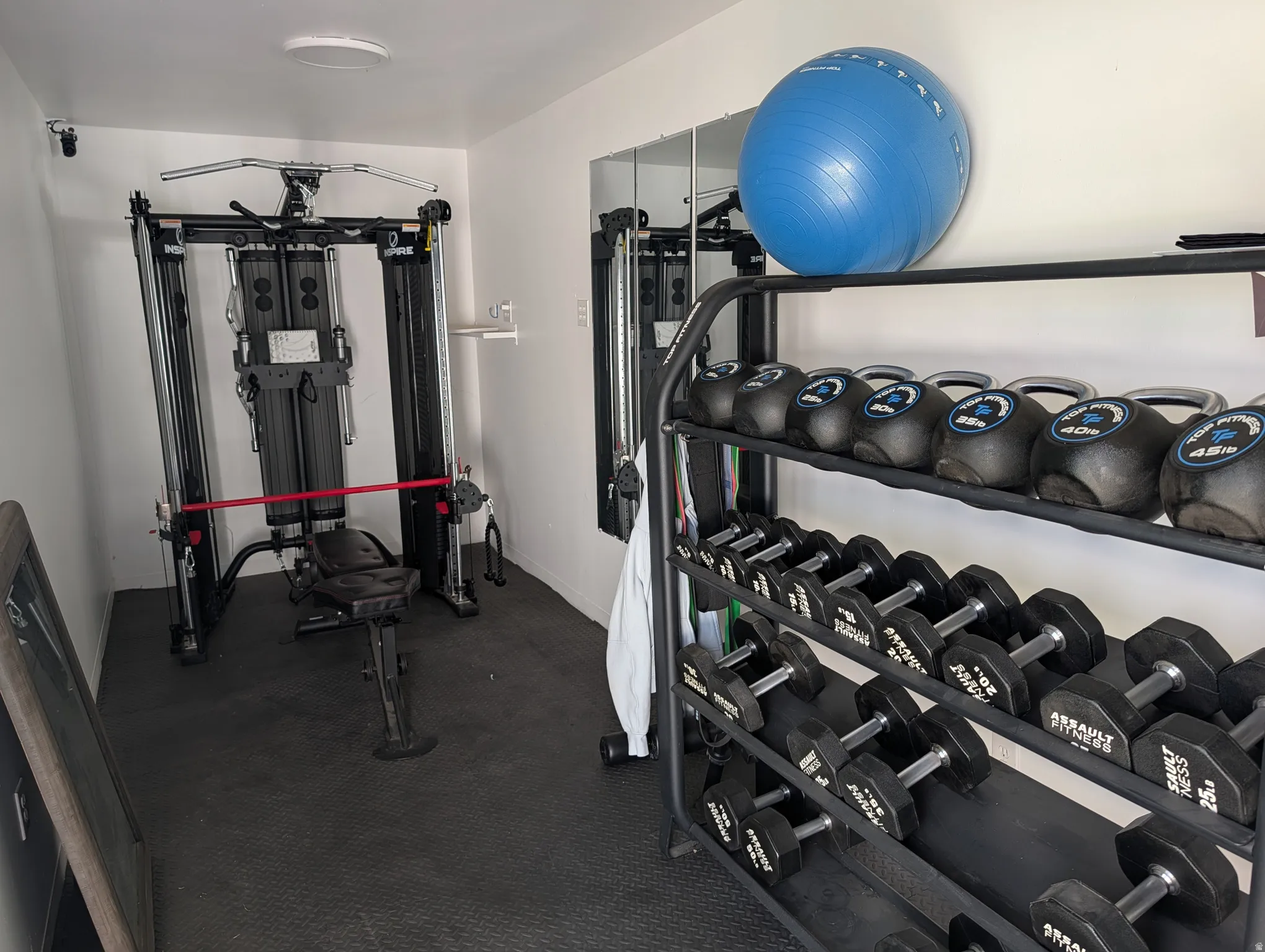 Dedicated fitness space featuring rubberized flooring and bright white walls