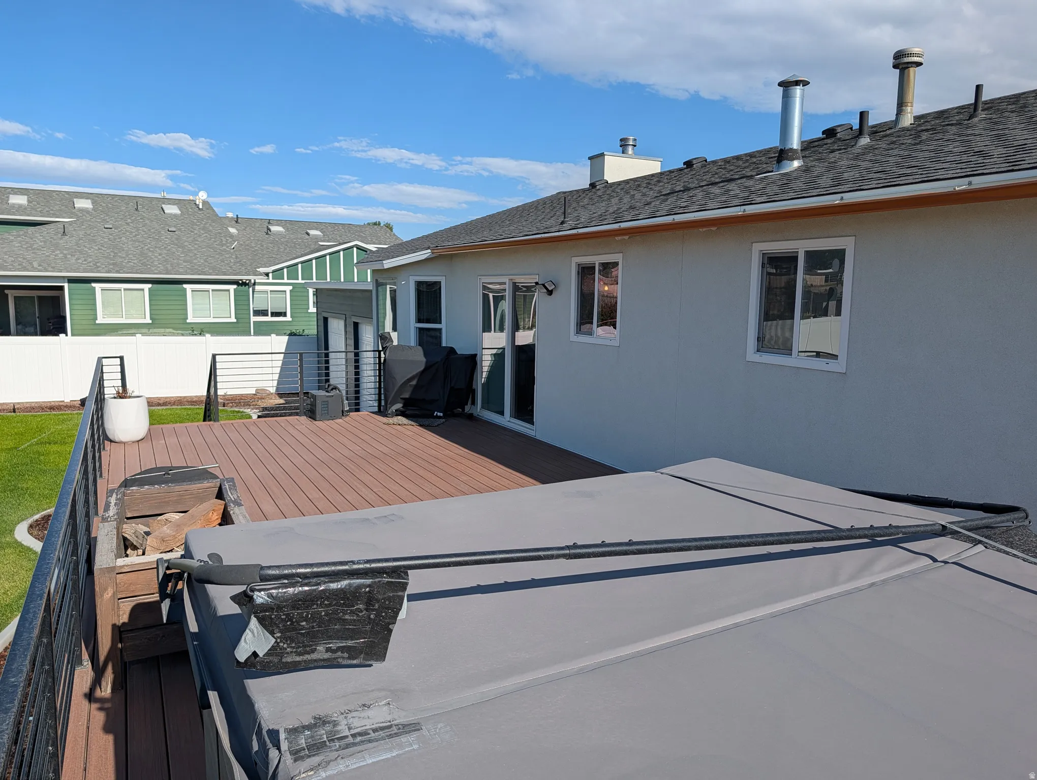 Expansive outdoor deck featuring wood-finish composite decking and modern black metal railings