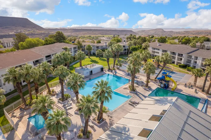 Expansive outdoor aquatic area featuring multiple pools, a water play structure, and ample sun deck space