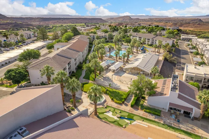 Community amenities featuring a putting green, multiple pools, and an extensive courtyard with mature palm trees